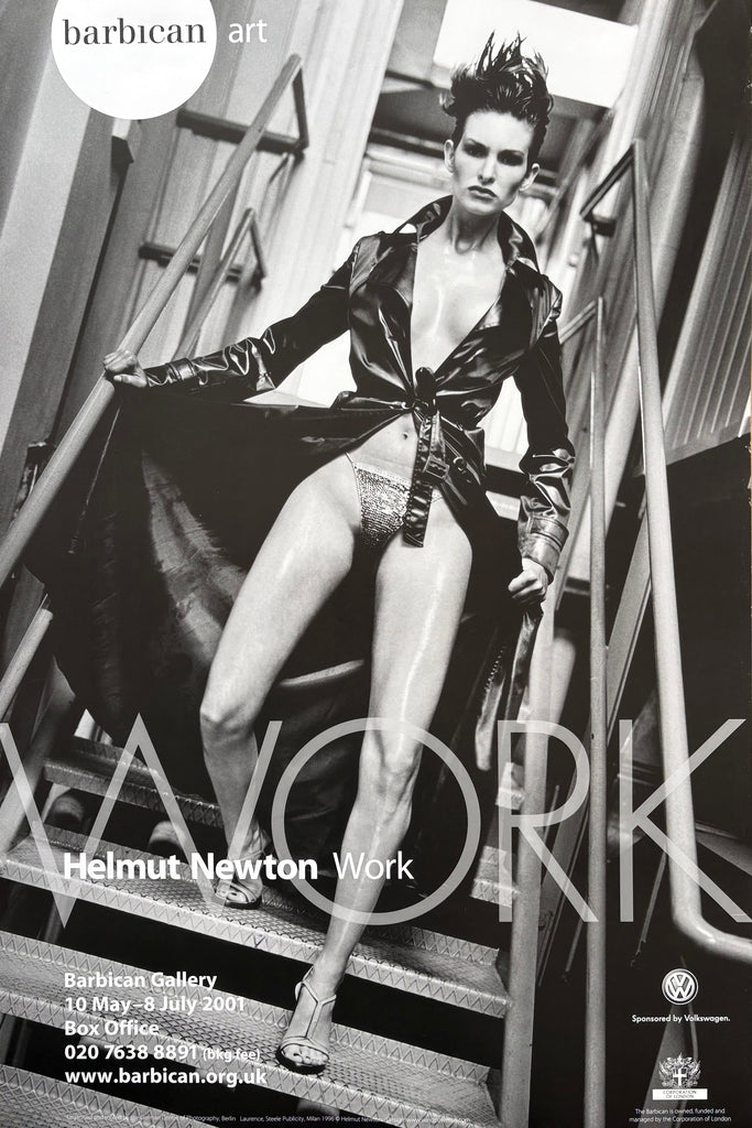 A black and white art poster for Helmut Newton's 'Work' exhibition at Barbican Gallery, featuring a dramatic fashion photograph of a model in a glossy leather jacket and shorts on metal stairs.